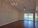 A chandelier and fan adorn this living room with a sliding glass door overlooking the fenced in back yard at 13546 Summerton Dr, Orlando, FL 32824