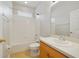 Clean bathroom with tub-shower, white tile surround, wood cabinets, and bright vanity at 13850 Amelia Pond Dr, Windermere, FL 34786