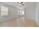 Bedroom showcasing light wood floors, ceiling fan, and bright natural light from two windows at 13850 Amelia Pond Dr, Windermere, FL 34786