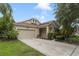 Charming single-Gathering home with a well-maintained lawn, attached garage, and inviting front entry at 13850 Amelia Pond Dr, Windermere, FL 34786