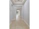 Hallway with beige tile flooring and a decorative tray ceiling at 13850 Amelia Pond Dr, Windermere, FL 34786