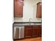 Modern kitchen with stainless steel dishwasher, dark wood cabinets, and stone countertops at 14147 Mailer Blvd, Orlando, FL 32828