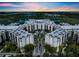 Stunning aerial view of the resort-style condo community with beautiful landscaping, lakes, and a vibrant sunset backdrop at 14501 Grove Resort Ave # 3239, Winter Garden, FL 34787
