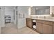 Elegant main bathroom featuring a double vanity with storage and modern lighting, with walk-in closet access at 14501 Grove Resort Ave # 3239, Winter Garden, FL 34787