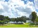 Scenic view of the park, showcasing lush greenery, a lake, and distant buildings under a bright, cloudy sky at 151 E Washington St # 508, Orlando, FL 32801