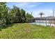 A large backyard featuring lush greenery and a screened pool, providing a private oasis at 1736 Saxon Blvd, Deltona, FL 32725