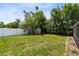 Green backyard with a storage building and white vinyl fence and an old rock border at 1736 Saxon Blvd, Deltona, FL 32725