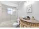 Well-lit bathroom featuring tiled shower with glass door and custom vanity at 1736 Saxon Blvd, Deltona, FL 32725