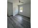Bright bedroom with gray wood-look flooring, closet, and a window at 1754 35Th Nw St, Winter Haven, FL 33881