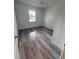 Light and airy bedroom with gray wood-look flooring and a bright window at 1754 35Th Nw St, Winter Haven, FL 33881