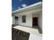 Inviting front porch with a freshly painted red door and grey trim at 1754 35Th Nw St, Winter Haven, FL 33881