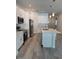 Well-lit kitchen featuring an island, modern appliances, stylish fixtures, and light wood-look floors at 1754 35Th Nw St, Winter Haven, FL 33881