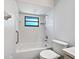 Bathroom featuring a tub-shower combination with a window and a toilet at 1818 Portview Ave, Deltona, FL 32738
