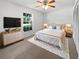 Cozy bedroom with a queen-sized bed, soft carpet, dresser, and a view of the outdoors at 1818 Portview Ave, Deltona, FL 32738