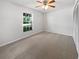 Minimalist bedroom featuring soft carpet, natural light, and a closet at 1818 Portview Ave, Deltona, FL 32738