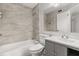 The updated bathroom features grey cabinetry, tile surround and a tub with shower at 1924 Lake Atriums Cir # 52, Orlando, FL 32839