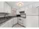 Functional kitchen with white cabinets, granite countertops, and modern appliances including dishwasher at 1924 Lake Atriums Cir # 52, Orlando, FL 32839