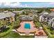 Aerial view of the community pool and clubhouse with surrounding buildings and landscaping at 1924 Lake Atriums Cir # 52, Orlando, FL 32839