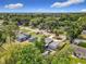 The aerial view highlights homes, mature trees, a pool, and multiple storage sheds, set within a well-established neighborhood at 219 E Fern Dr, Orange City, FL 32763