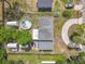 An aerial view of the property reveals a circular driveway, above ground pool and multiple storage sheds within a fenced yard at 219 E Fern Dr, Orange City, FL 32763
