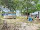 An above ground pool is the focal point of this backyard with a covered porch and storage shed among the mature trees at 219 E Fern Dr, Orange City, FL 32763