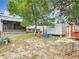 A spacious, grassy backyard features a screened porch, covered patio, with multiple storage sheds providing ample outdoor living and storage at 219 E Fern Dr, Orange City, FL 32763