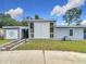 Inviting single-story home with a modern exterior, manicured lawn and stone walkway at 219 E Fern Dr, Orange City, FL 32763