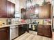Well-equipped kitchen with dark wood cabinets, granite countertops, and stainless steel appliances at 219 E Fern Dr, Orange City, FL 32763