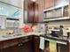 A well-equipped kitchen featuring dark wood cabinets, granite countertops, and modern stainless-steel appliances at 219 E Fern Dr, Orange City, FL 32763