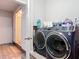 Modern laundry room with an open doorway to the bathroom and gray front load washer and dryer at 219 E Fern Dr, Orange City, FL 32763