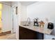 Wet bar area with a granite countertop, stainless steel sink, and dark wood cabinets at 219 E Fern Dr, Orange City, FL 32763