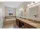 Bathroom featuring double sinks, granite countertops, and a soaking tub at 2210 Romanum Dr, Winter Garden, FL 34787