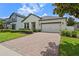 Attractive single-story home with brick driveway, tidy landscaping, and attached two-car garage at 2210 Romanum Dr, Winter Garden, FL 34787