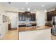 Open kitchen with granite countertops, stainless steel appliances, and dark wood cabinetry at 2210 Romanum Dr, Winter Garden, FL 34787