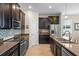 Stylish kitchen with stainless steel appliances, dark cabinetry, and a mosaic tile backsplash at 2210 Romanum Dr, Winter Garden, FL 34787