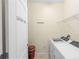 Bright laundry room with modern washer, dryer, overhead shelving and laundry themed door at 2210 Romanum Dr, Winter Garden, FL 34787