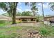 View of the home's backyard featuring a patio and fire pit surrounded by trees and a small shed at 236 Longhorn Dr, Apopka, FL 32712