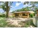 Backyard featuring mature trees and grass leading up to a patio with a charming porch swing at 236 Longhorn Dr, Apopka, FL 32712