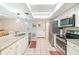 White kitchen with stainless appliances, long countertop, and tile floor offers ample workspace at 236 Longhorn Dr, Apopka, FL 32712