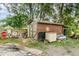 View of a brown shed located in the backyard with a sun decoration and various yard tools at 236 Longhorn Dr, Apopka, FL 32712