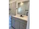 Modern bathroom with gray vanity, white countertop, and tiled shower at 2421 Queenswood Cir, Kissimmee, FL 34743