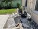 Pool equipment area featuring pumps, pipes, and gravel, essential for maintaining a clean and functional pool at 2421 Queenswood Cir, Kissimmee, FL 34743