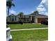 Inviting single-story home with lush landscaping, mature palms and two car garage at 2421 Queenswood Cir, Kissimmee, FL 34743