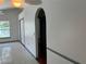 View of the hallway featuring tiled and hardwood floors, archway, neutral paint color, and natural light at 2421 Queenswood Cir, Kissimmee, FL 34743