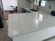 Close-up of a kitchen's quartz countertop with a view into an adjacent room being worked on at 2421 Queenswood Cir, Kissimmee, FL 34743