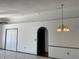View of living room featuring tiled and hardwood floors, archway, neutral paint color, and modern lighting fixture at 2421 Queenswood Cir, Kissimmee, FL 34743