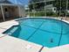 A refreshing enclosed pool with clear blue water, surrounded by a spacious patio deck for outdoor enjoyment at 2421 Queenswood Cir, Kissimmee, FL 34743