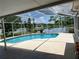 Enclosed pool with a tranquil lake view, blending relaxation and nature for an idyllic outdoor experience at 2421 Queenswood Cir, Kissimmee, FL 34743