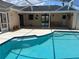 Enclosed pool featuring blue tile trim and multiple entry steps providing a refreshing oasis for relaxation and recreation at 2421 Queenswood Cir, Kissimmee, FL 34743