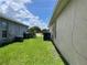 A narrow side yard with lush green grass and partial views of surrounding homes, showcasing outdoor space at 2421 Queenswood Cir, Kissimmee, FL 34743
